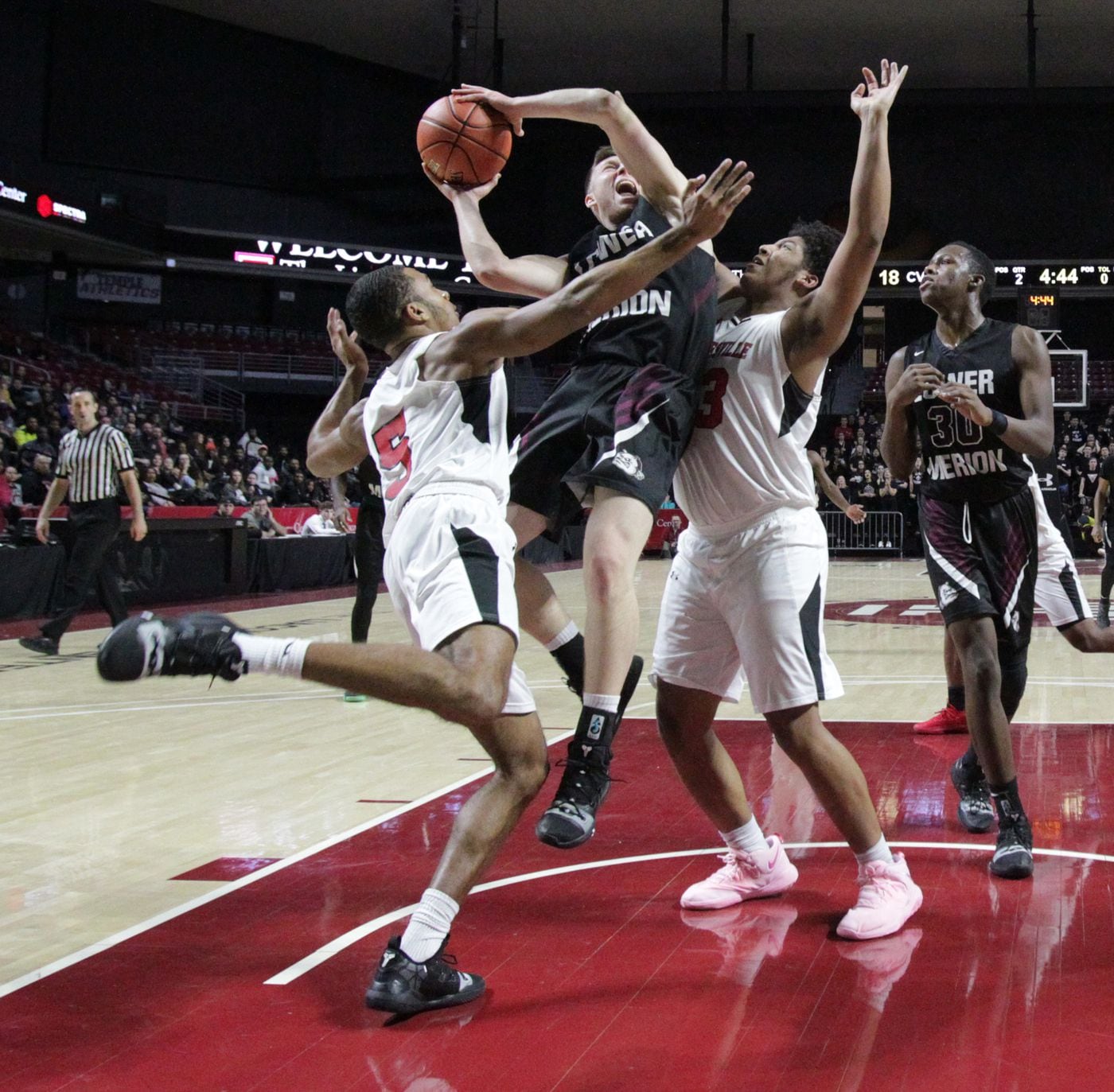 Theo Henry, center, of Lower Merion gets sandwiched between Dymere Miller, left, and Tione Holmes of Coatesville in the PIAA District 1 boys basketball semifinals at the Liacouras Center on Feb. 26, 2019.